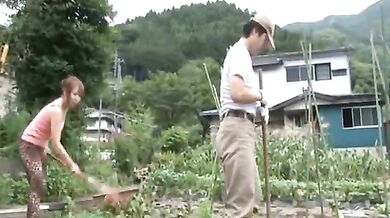 Mature Japanese farmer woman bangs on the rice field outside
