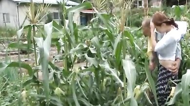 Mature Japanese farmer woman bangs on the rice field outside