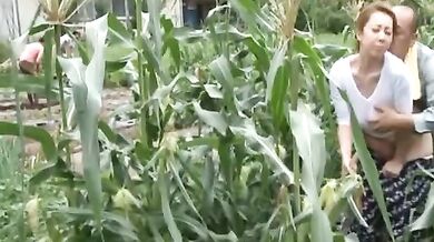 Mature Japanese farmer woman bangs on the rice field outside